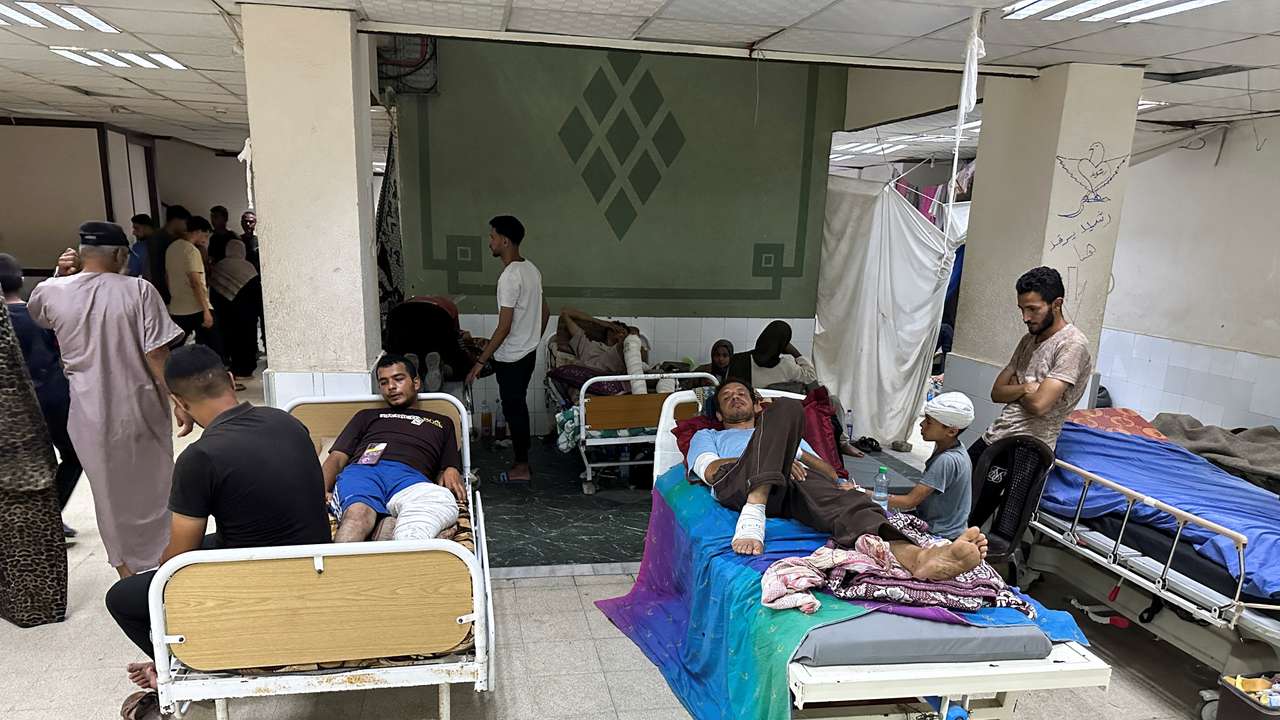 Wounded Palestinians, who were injured in an Israeli strike, lie on beds as Gaza's overwhelmed Al-Aqsa hospital struggles to treat the wounded, amid the Israel-Hamas conflict, in Deir Al-Balah