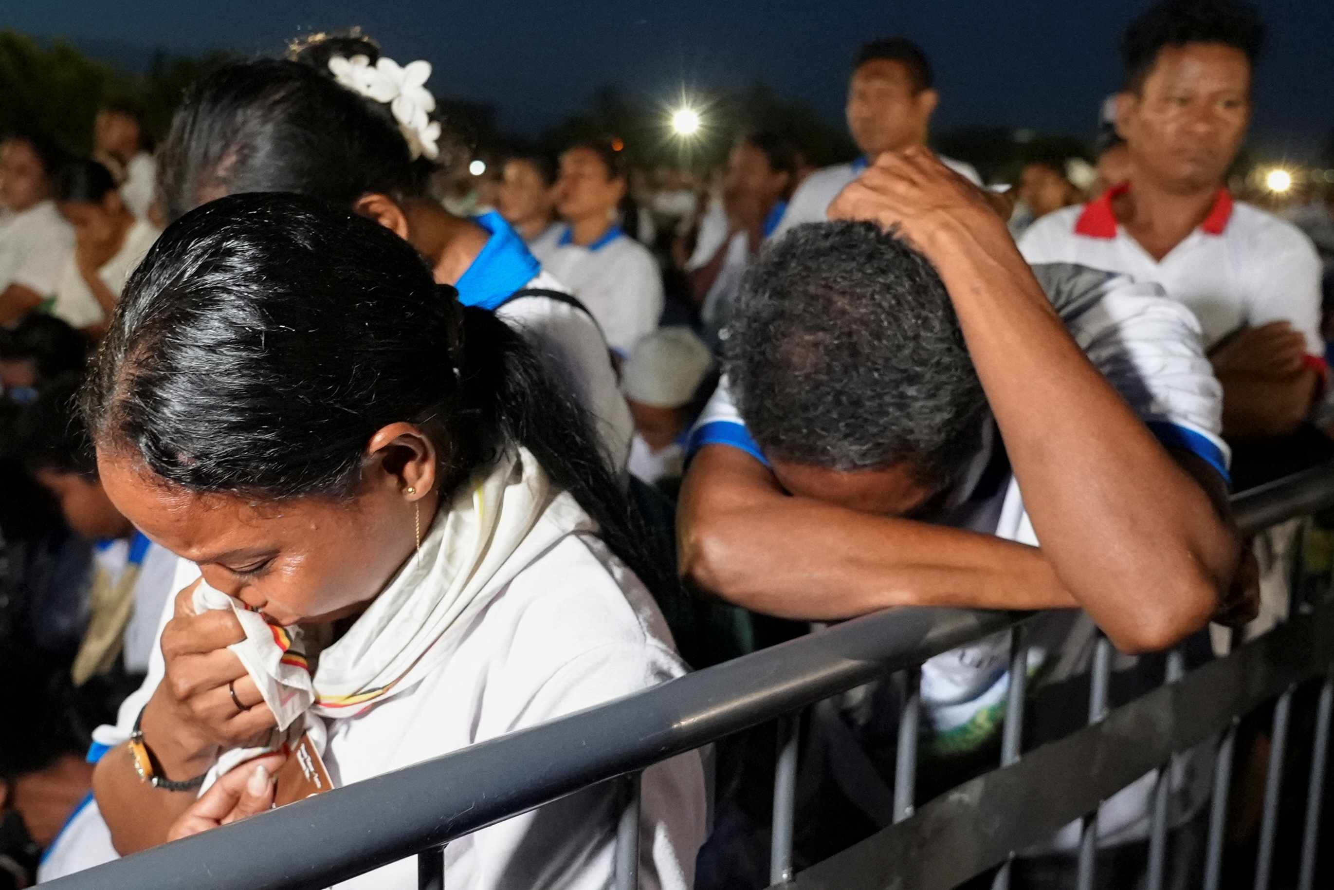 Timorese Catholics react as they pray for Pope Francis during a Requiem Mass at Tasi Tolu in Dili