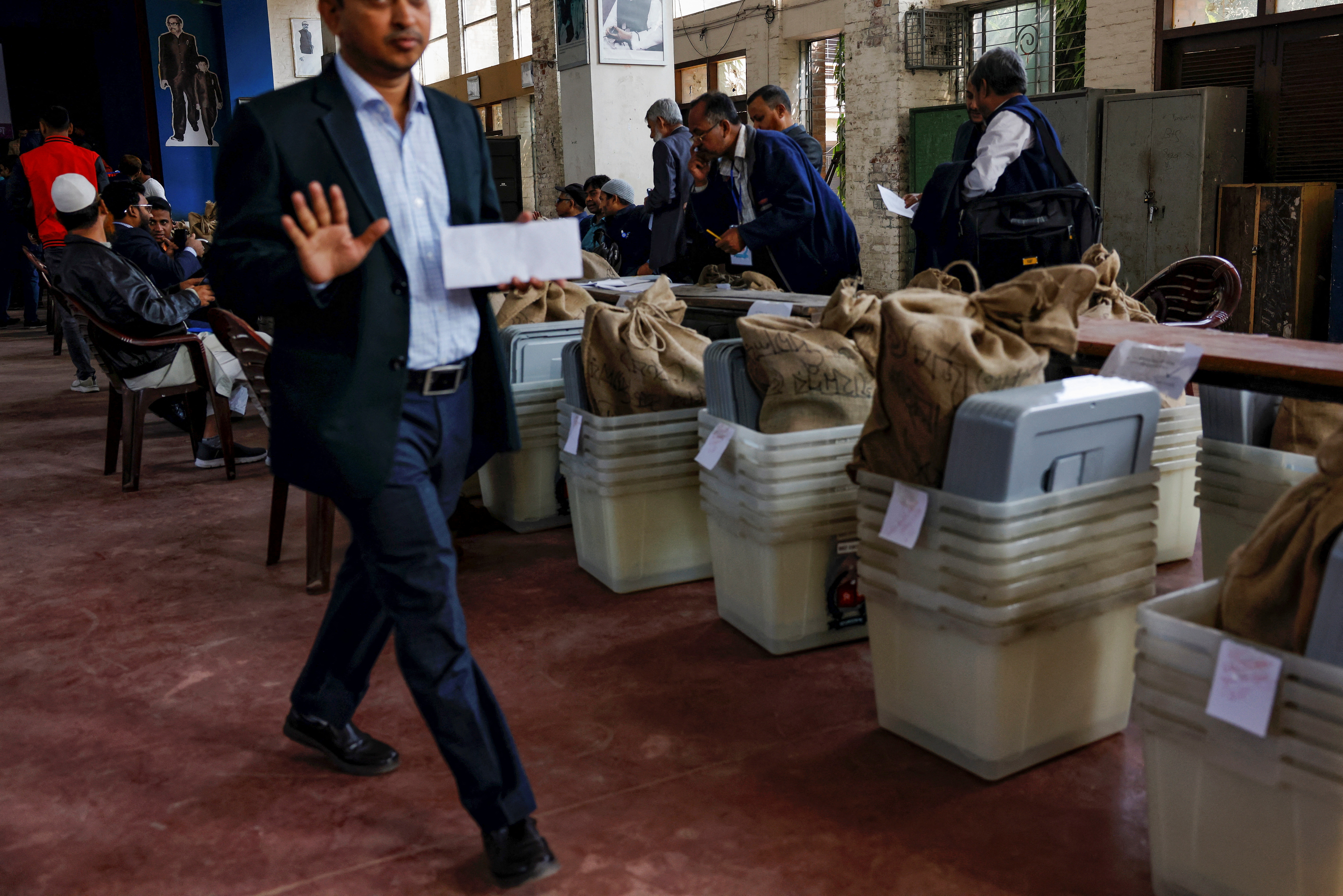 Officials prepare documents before distributing ballot boxes to the voting centres as part of election preparation, a day ahead of the general election in Dhaka