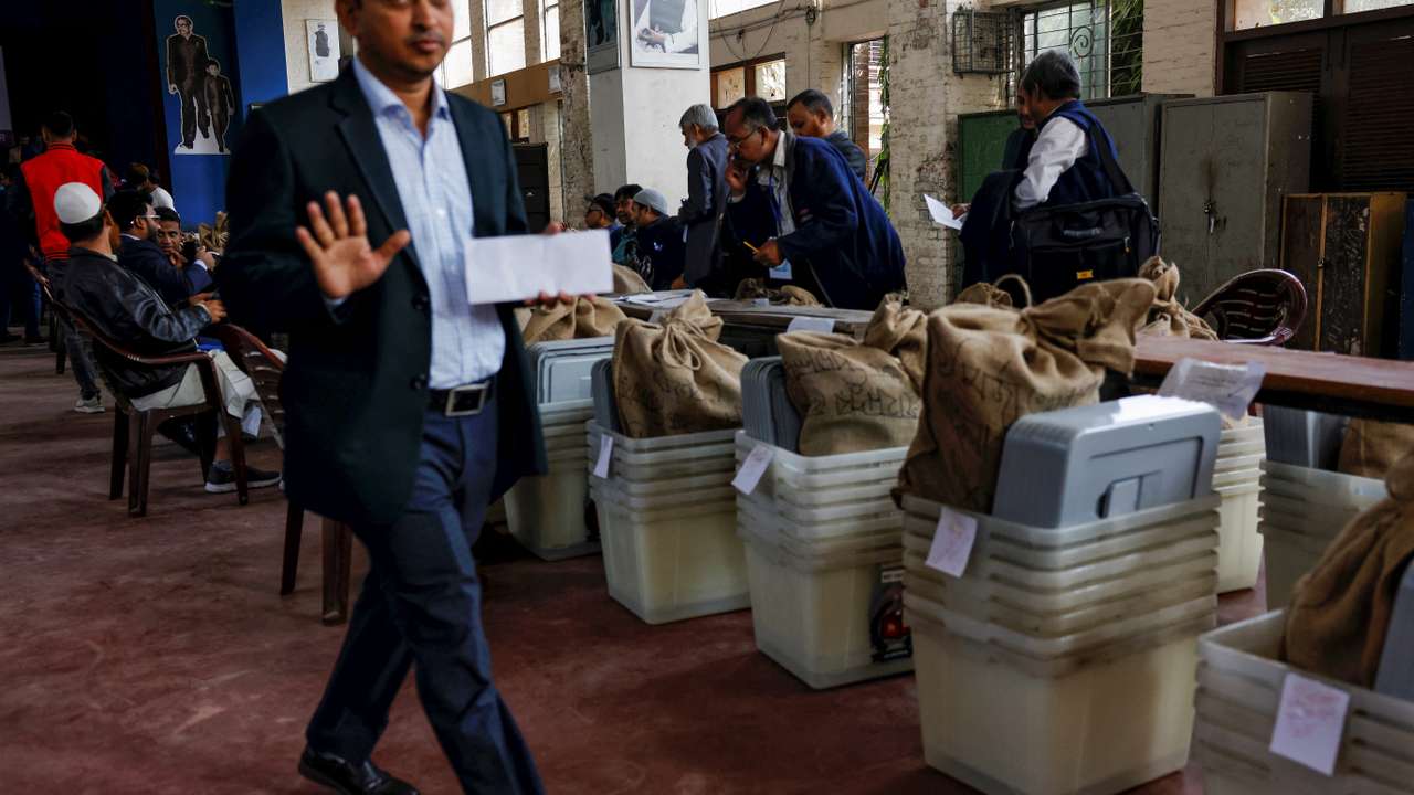 Officials prepare documents before distributing ballot boxes to the voting centres as part of election preparation, a day ahead of the general election in Dhaka