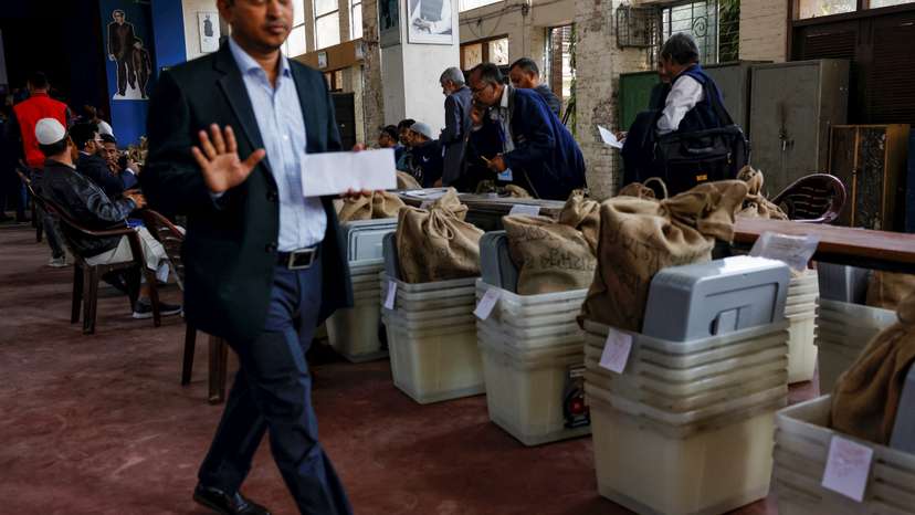 Officials prepare documents before distributing ballot boxes to the voting centres as part of election preparation, a day ahead of the general election in Dhaka