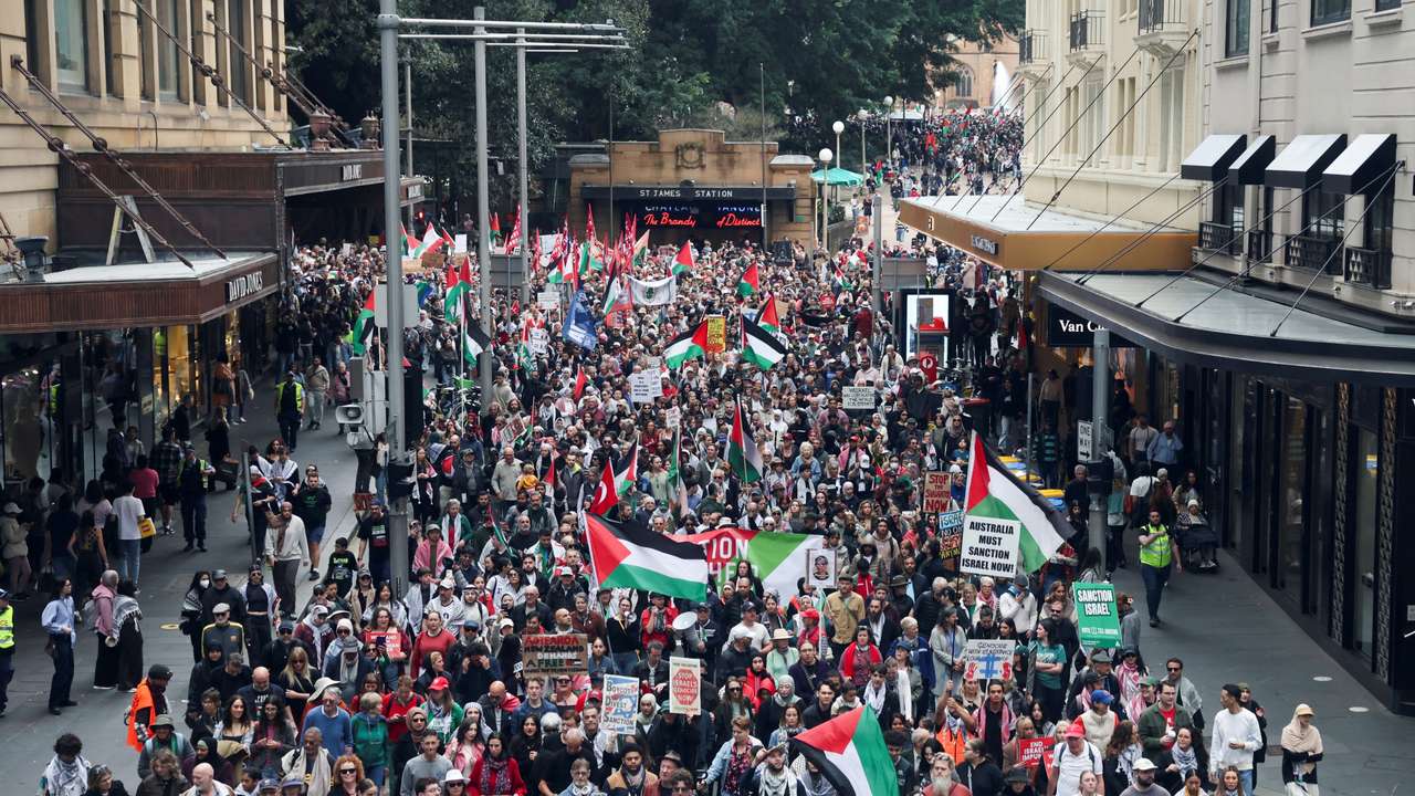 Demonstrators hold placards as they take part in the 'Nationwide March for Palestine' protest in Sydney
