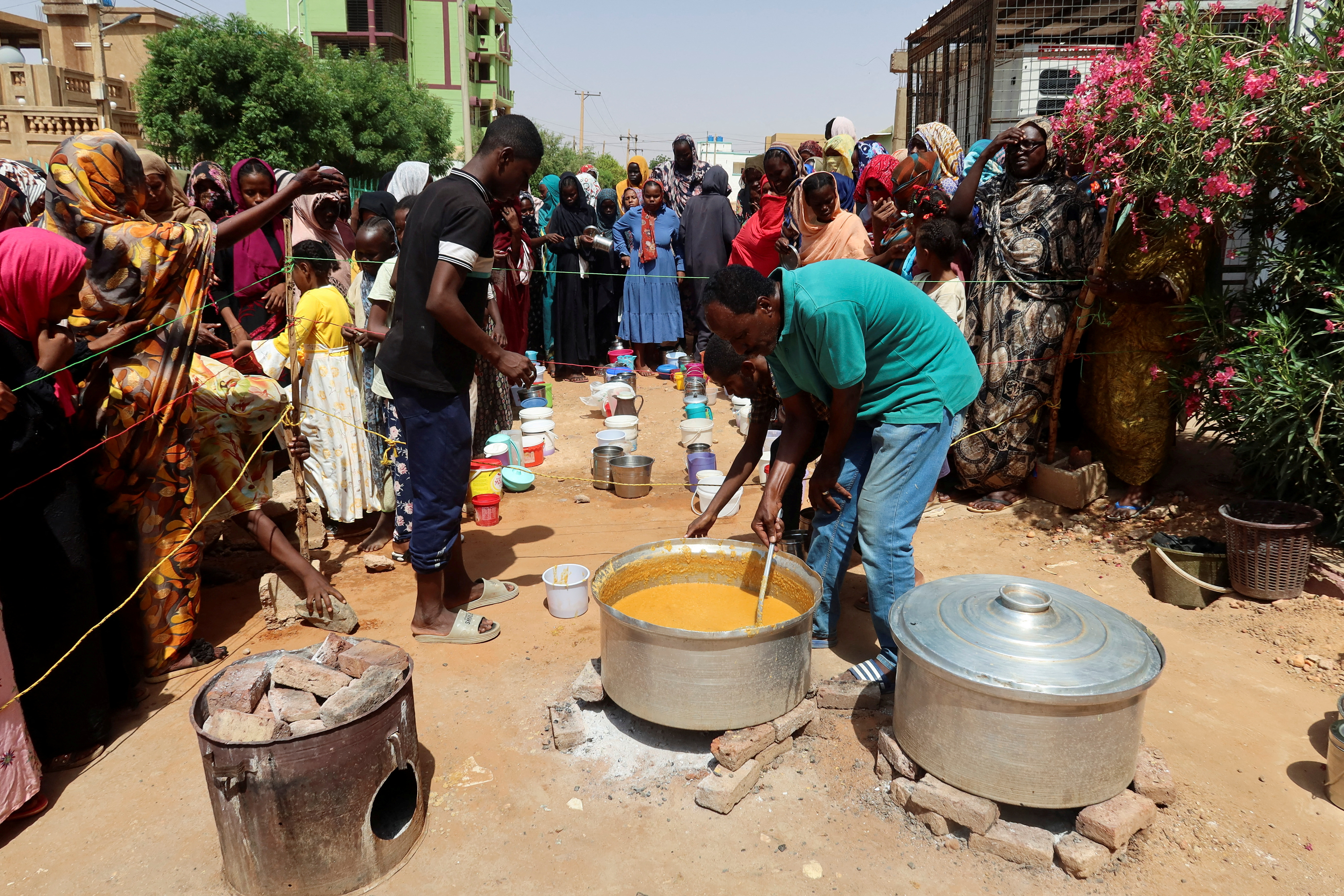 FILE PHOTO: A volunteer stirring food to be distributed to people in Omdurman