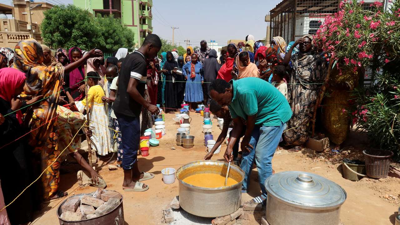 FILE PHOTO: A volunteer stirring food to be distributed to people in Omdurman