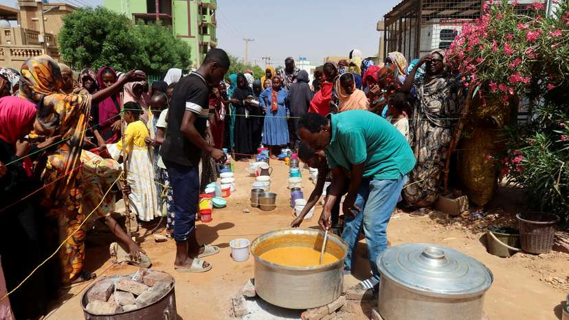 FILE PHOTO: A volunteer stirring food to be distributed to people in Omdurman
