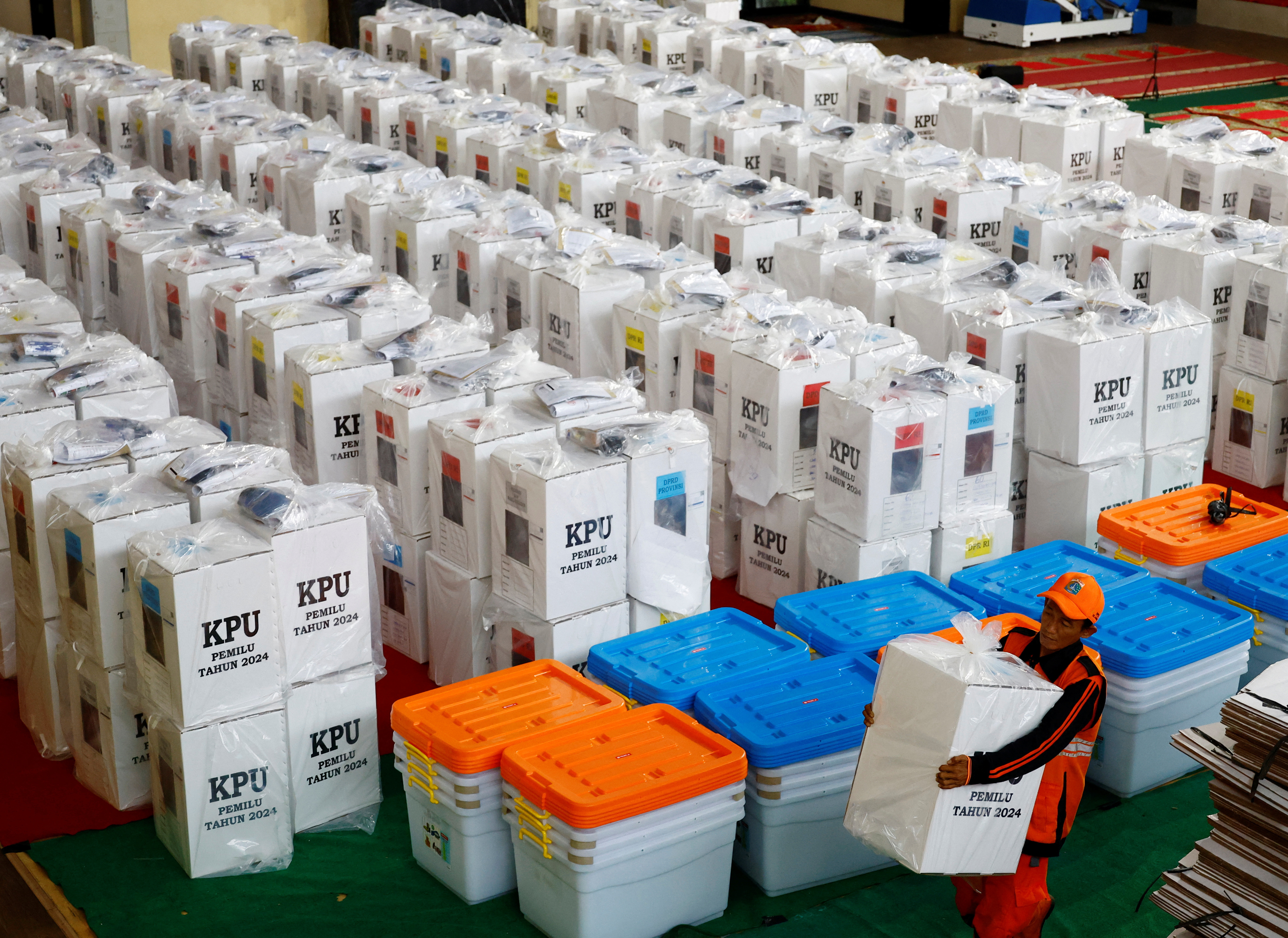 A worker carries a ballot box for distribution to polling stations at a distribution centre ahead of the presidential election in Jakarta