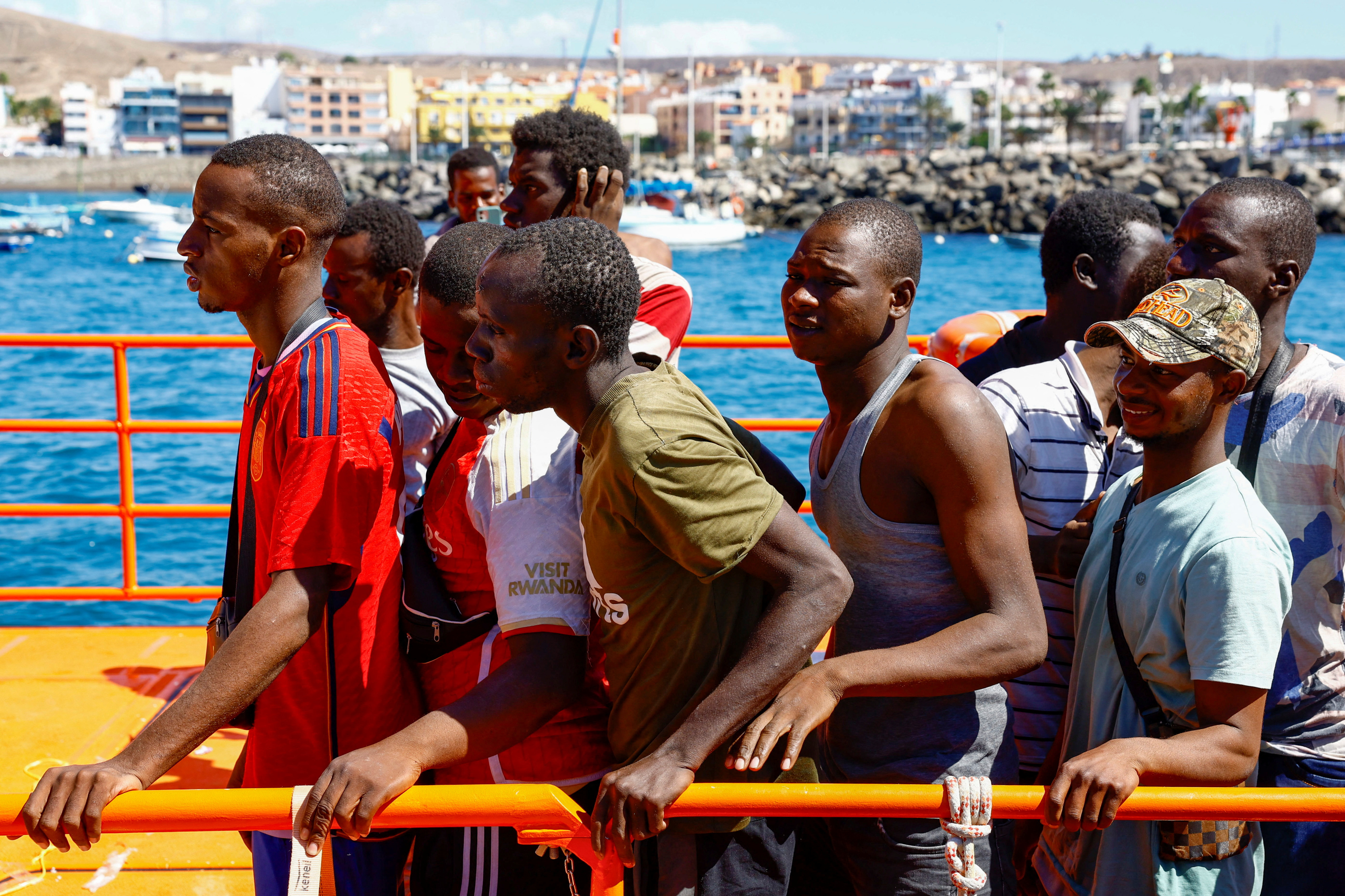 Migrants wait to disembark from a Spanish coast guard vessel, in the port of Arguineguin