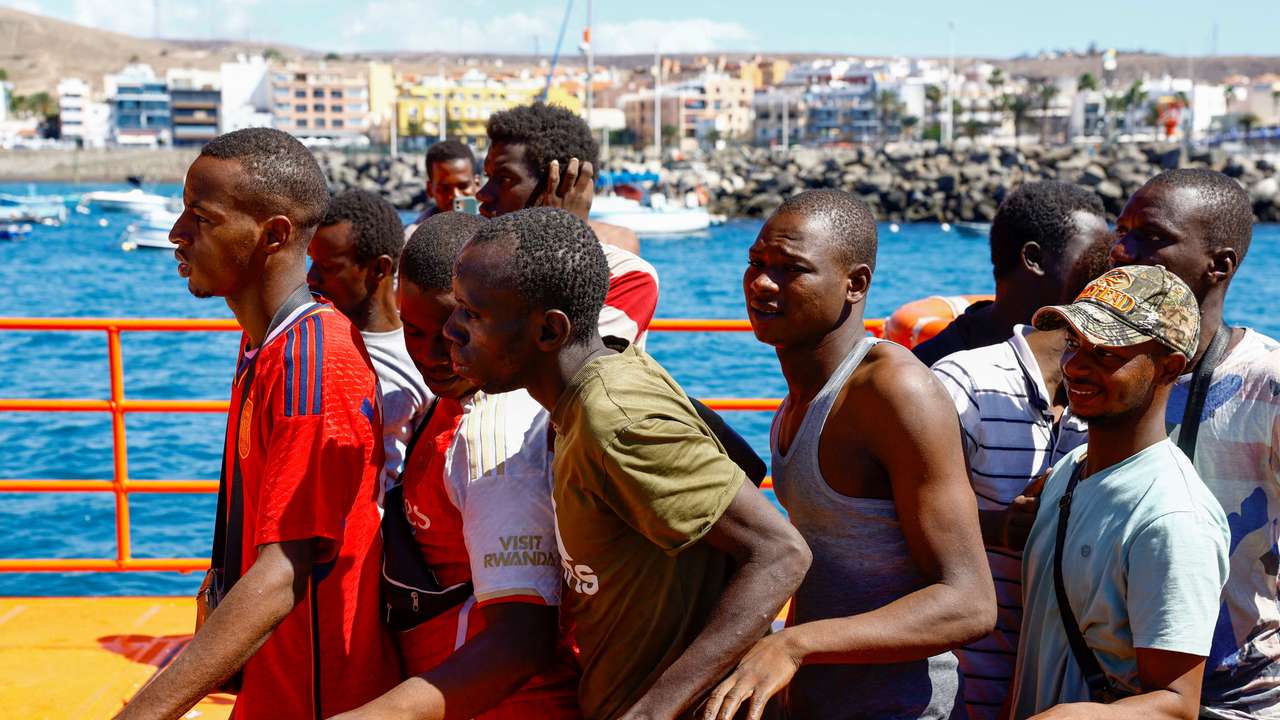 Migrants wait to disembark from a Spanish coast guard vessel, in the port of Arguineguin
