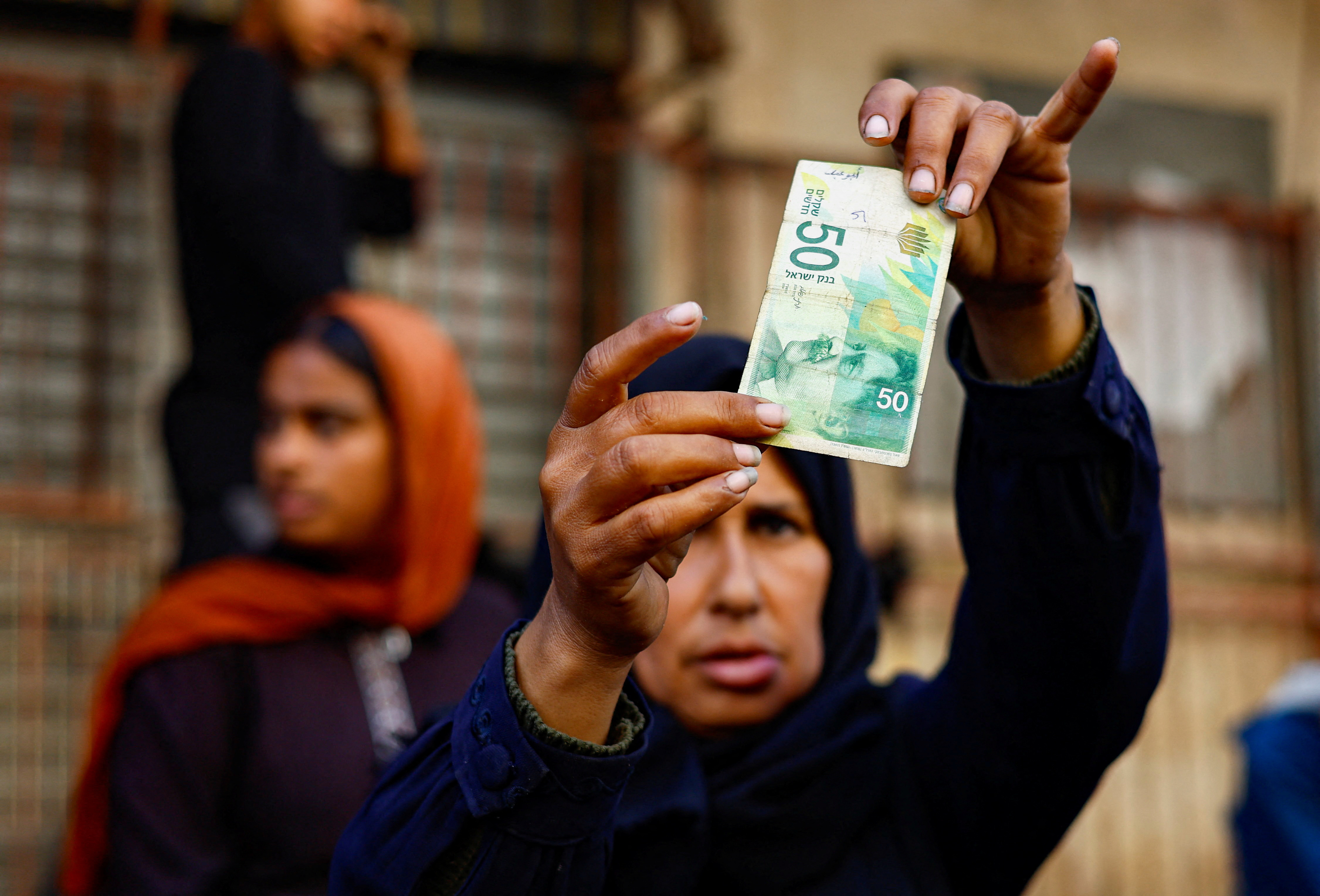 As the guns fall silent, Gazans find newly-reopened banks have no cash in Nuseirat