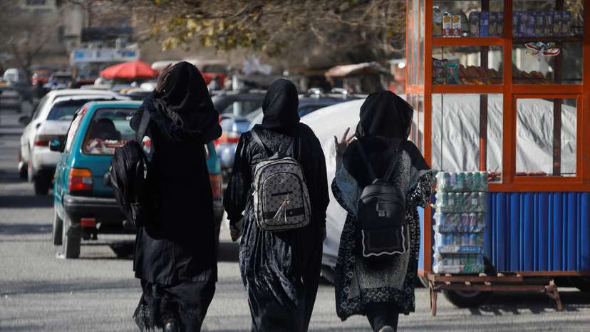 Afghan female students walk near Kabul University in Kabul
