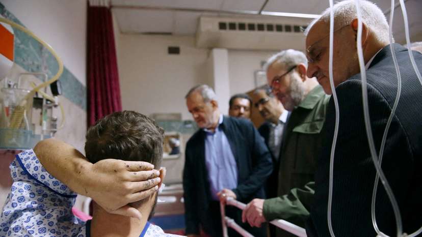 FILE PHOTO: Iran's President Masoud Pezeshkian visits one of the victims injured by pager explosions across Lebanon, in a hospital in Tehran