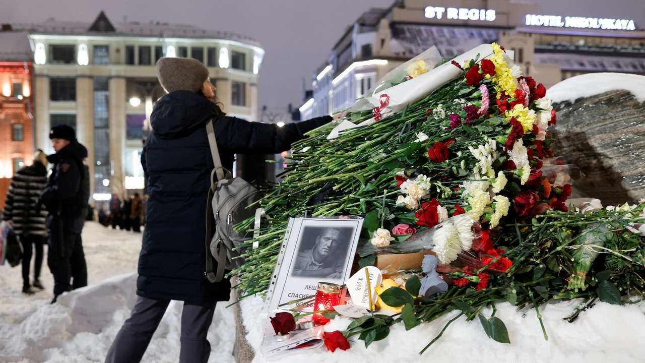 People gather at the monument to the victims of political repressions following the death of Alexei Navalny in Moscow