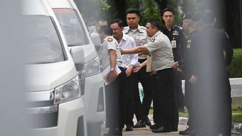Former Thai Prime Minister Thaksin Shinawatra is escorted by corrections officers in Bangkok