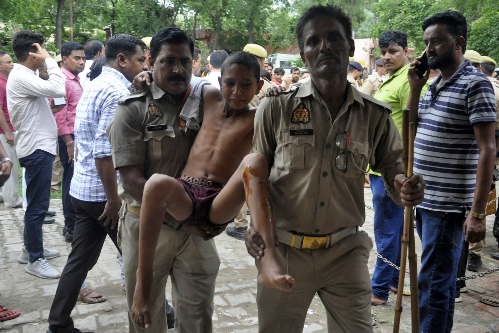 A boy, who was injured in a stampede at a religious gathering, reacts as he is brought to a hospital for treatment in Hathras district