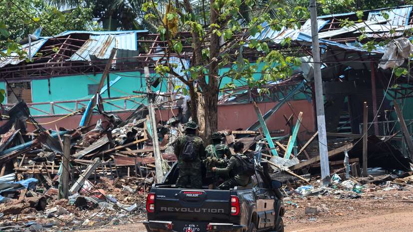 FILE PHOTO: Soldiers from the Karen National Liberation Army (KNLA) patrol , next to an area destroyed by Myanmar's airstrike in Myawaddy