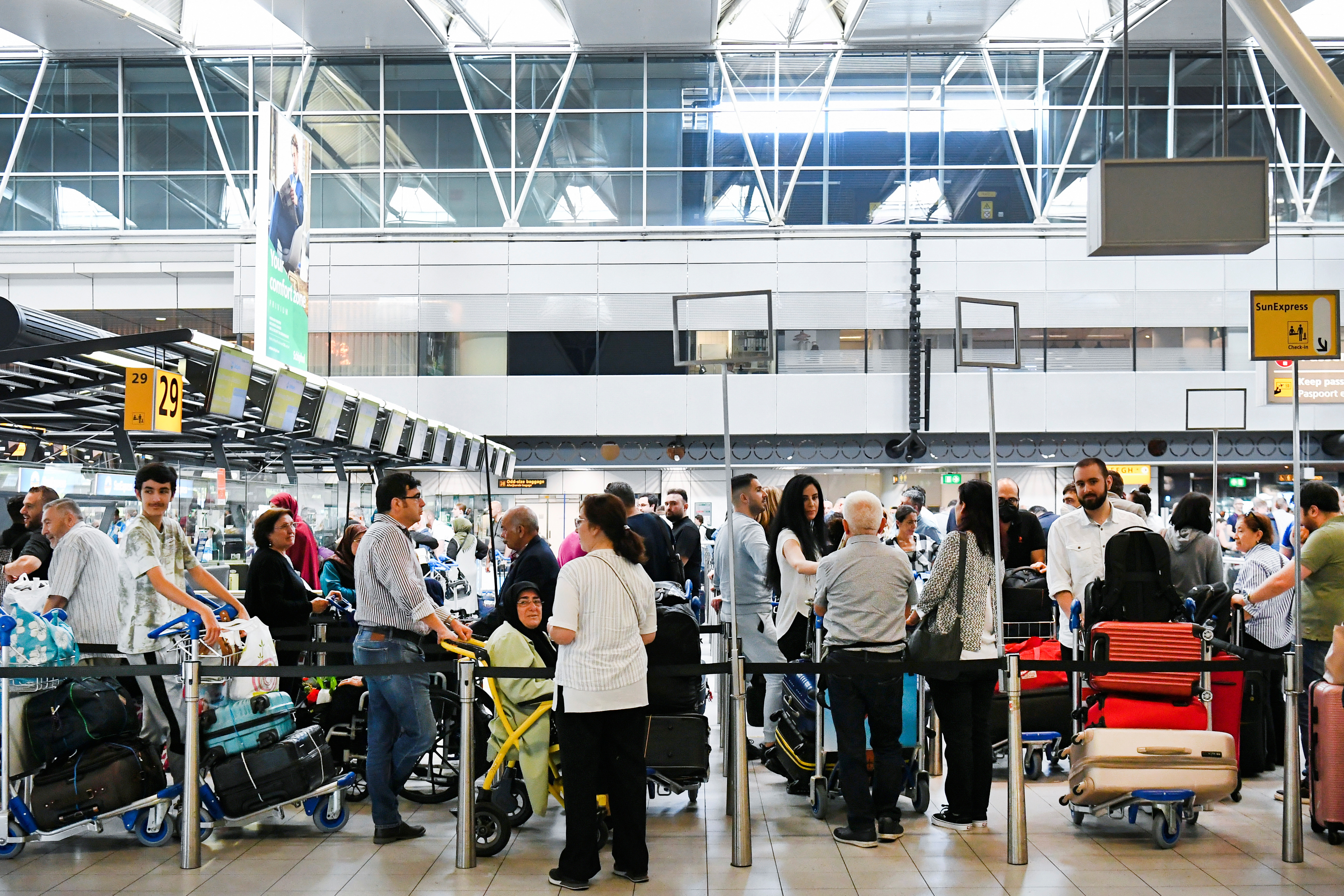 People wait in lines at Schiphol Airport in Amsterdam