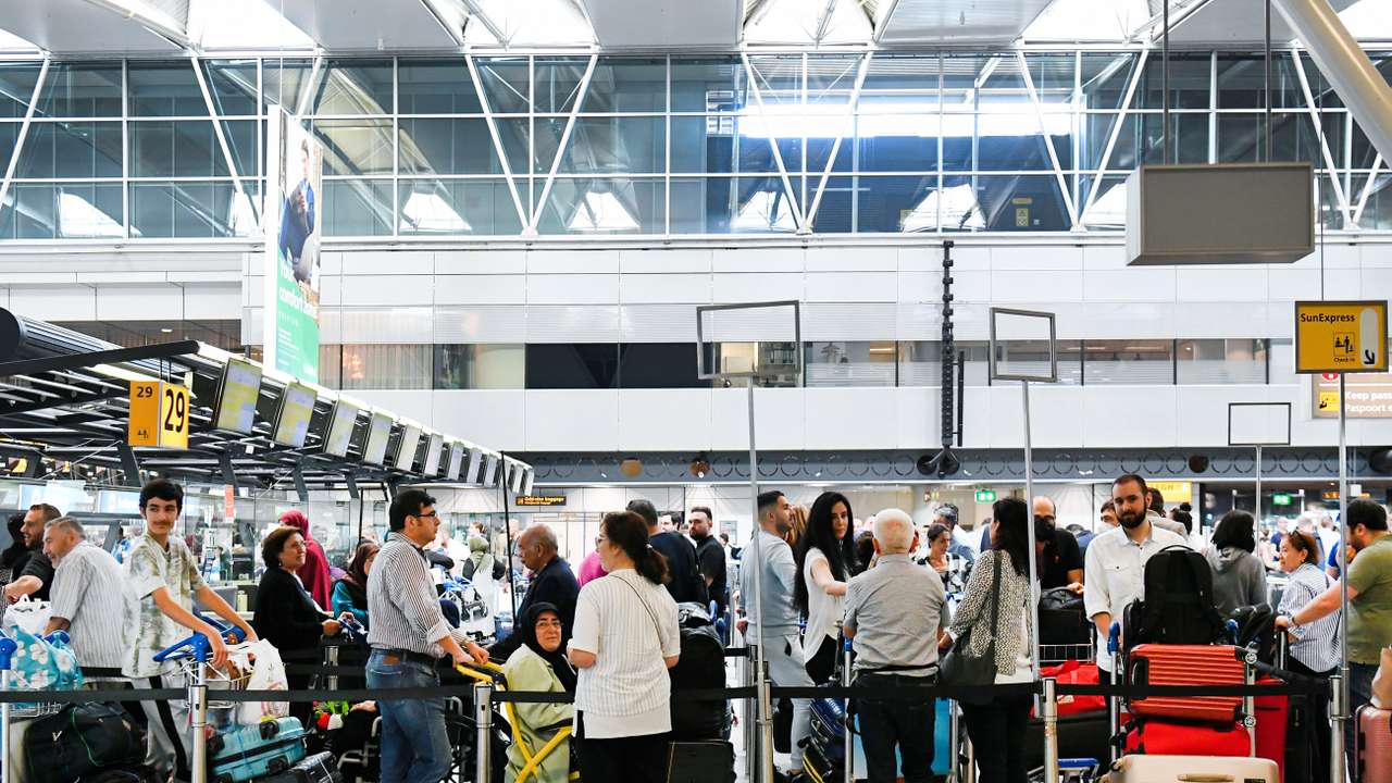 People wait in lines at Schiphol Airport in Amsterdam