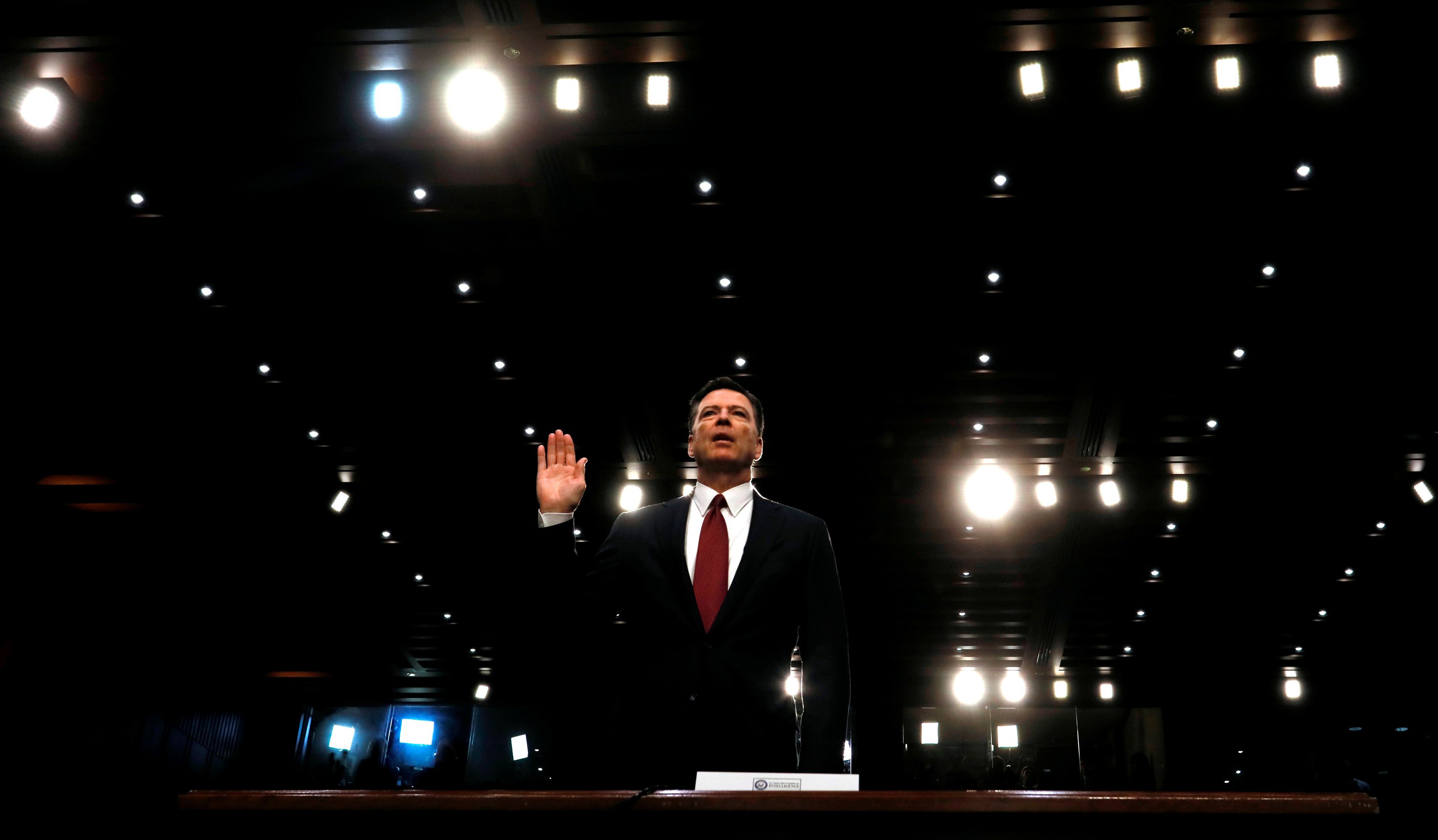 FILE PHOTO: Former FBI Director James Comey sworn in to testify at a hearing in Washington
