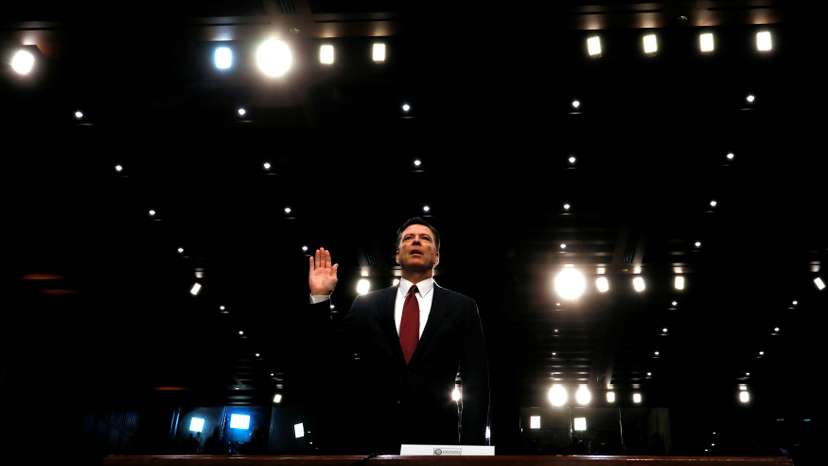 FILE PHOTO: Former FBI Director James Comey sworn in to testify at a hearing in Washington