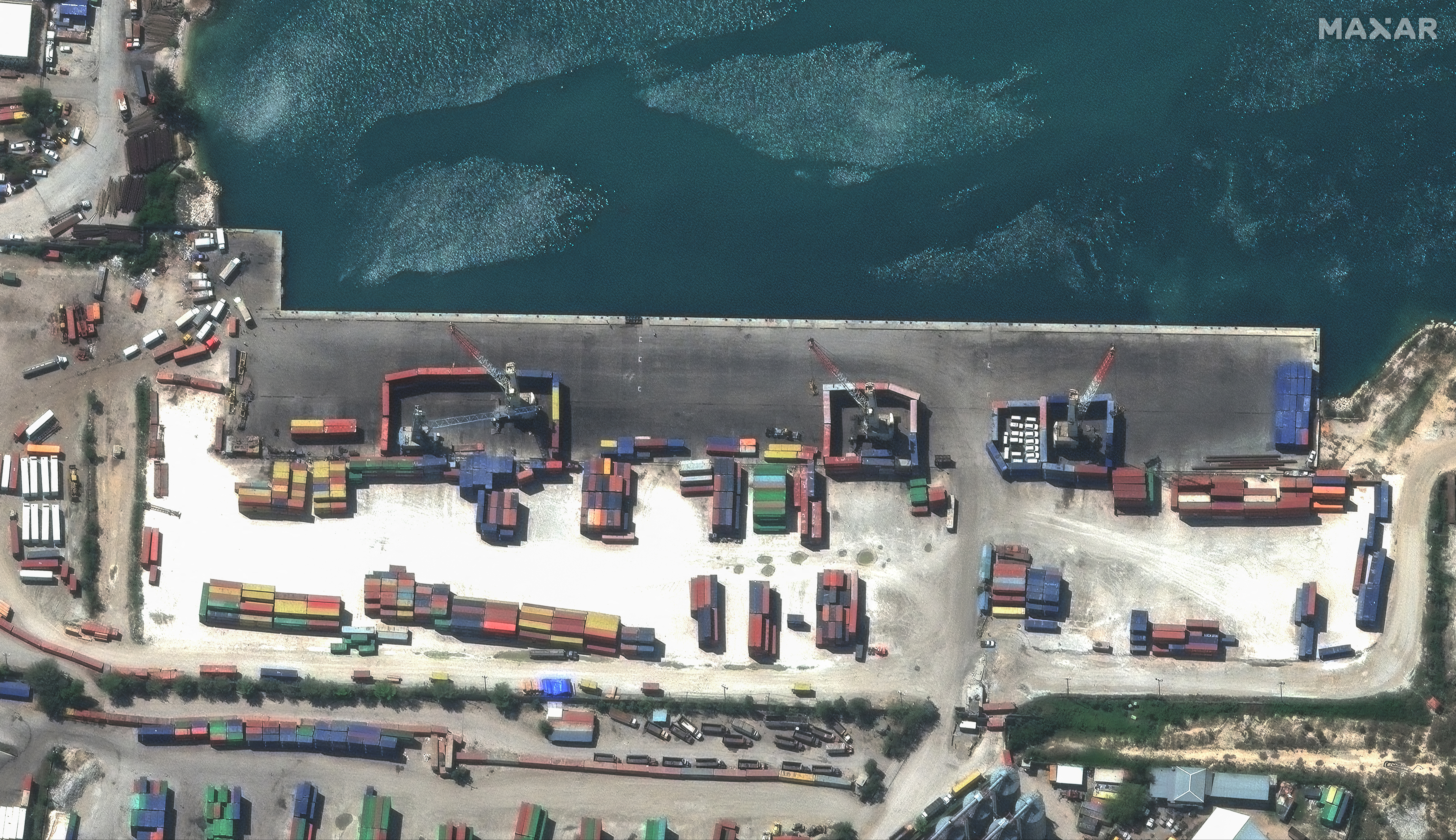 A satellite image shows shipping containers used to block access to heavy cranes, in Port-au-Prince