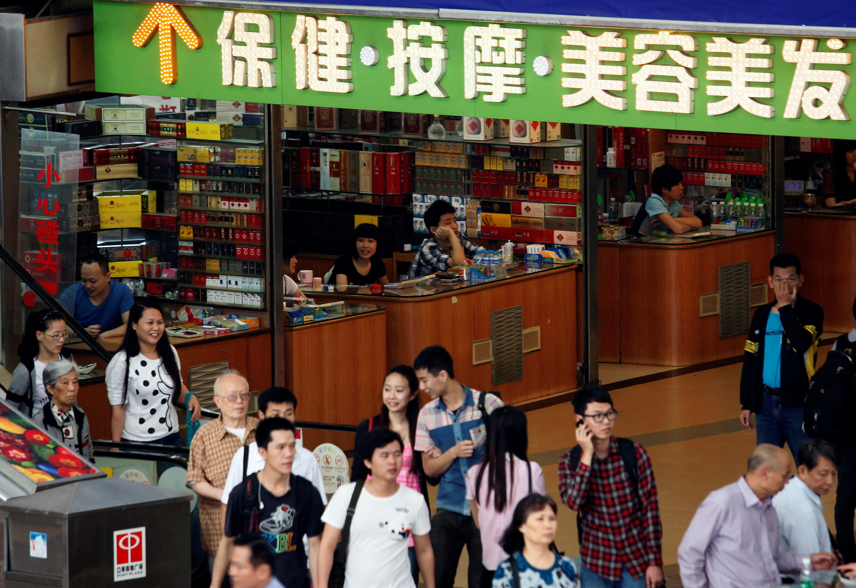 FILE PHOTO: Shoppers walk past small shops at an underground mall in Zhuhai