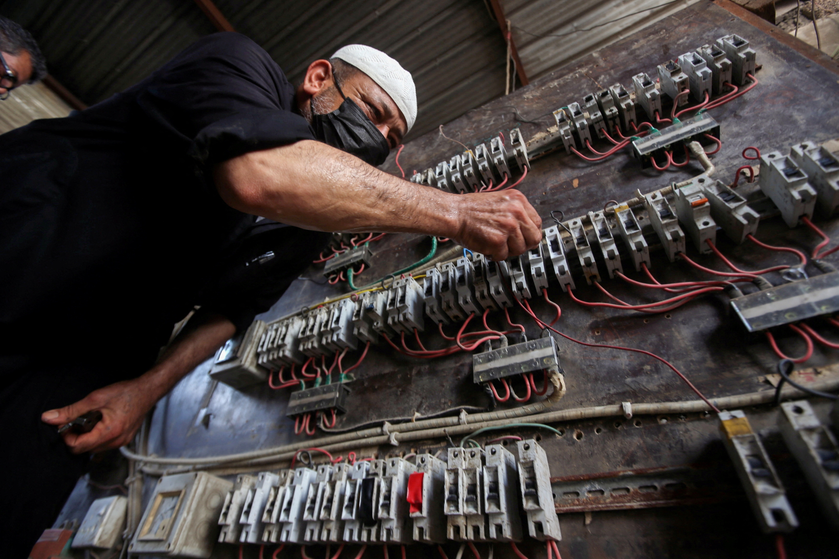 FILE PHOTO: A man works on an electrical generator board during power outages in Basra