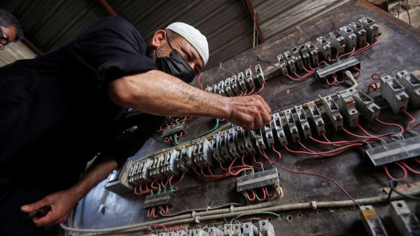 FILE PHOTO: A man works on an electrical generator board during power outages in Basra