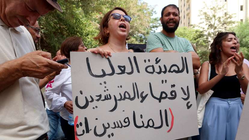 FILE PHOTO: A demonstrator carries a banner during a protest near the headquarters of the Electoral Commission in Tunis