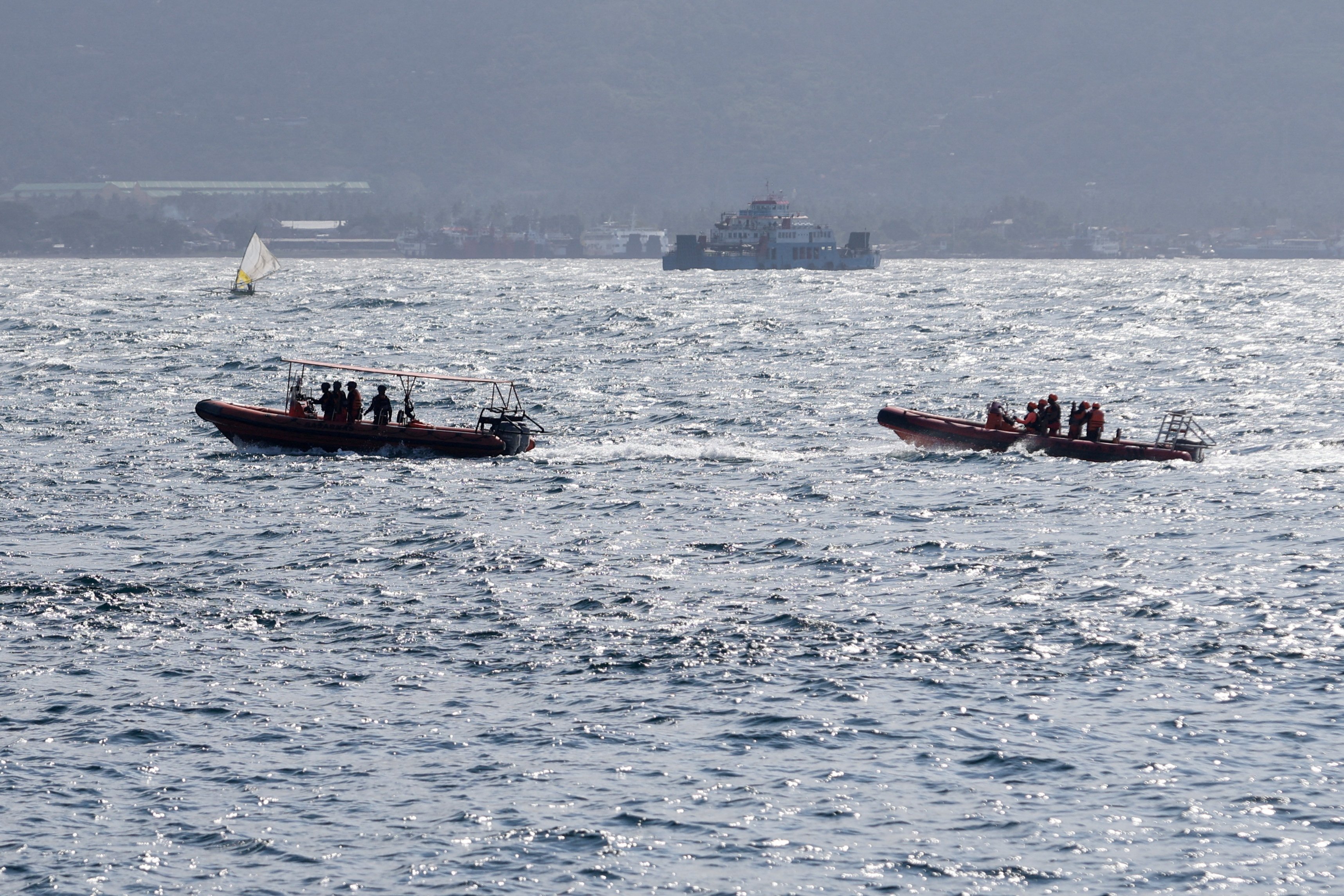 Indonesia rescue team members sail on dinghies during a search operation for missing passengers, after a ferry carrying 65 people sank near the Indonesian island of Bali, in Bali