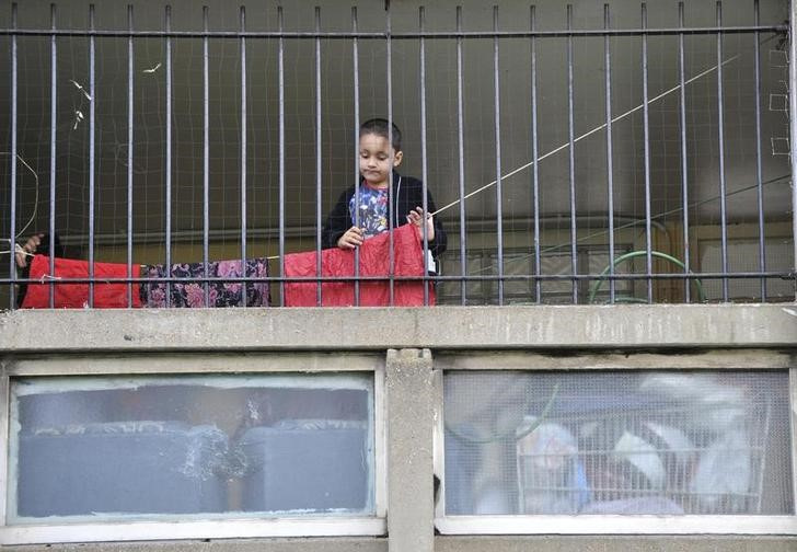 FILE PHOTO: A child plays behind railings on the Robin Hood Gardens estate in Poplar in East London