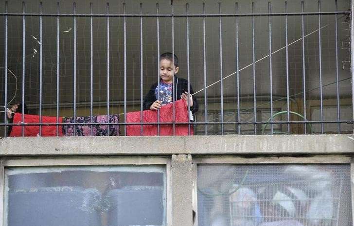 FILE PHOTO: A child plays behind railings on the Robin Hood Gardens estate in Poplar in East London