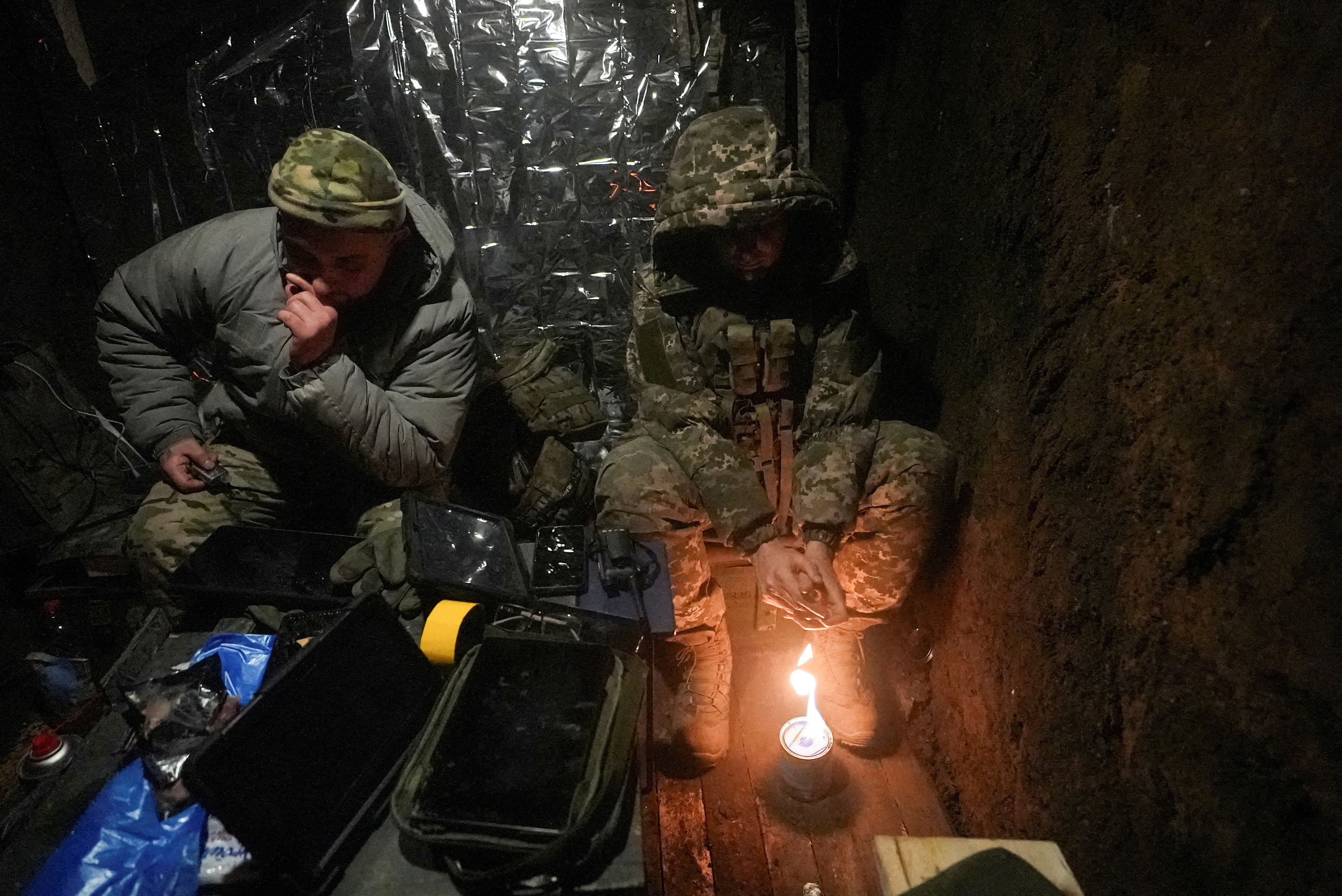 FILE PHOTO: Ukrainian servicemen warm up inside a dugout as they fly with a Vampire combat drone over positions of Russian troops near the frontline town of Bakhmut