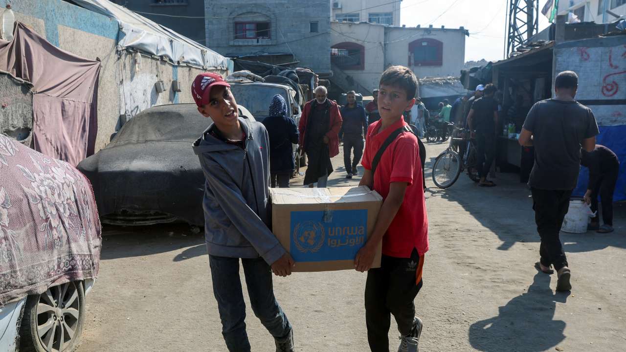 Palestinians receive aid from UNRWA in Deir Al-Balah, central Gaza Strip