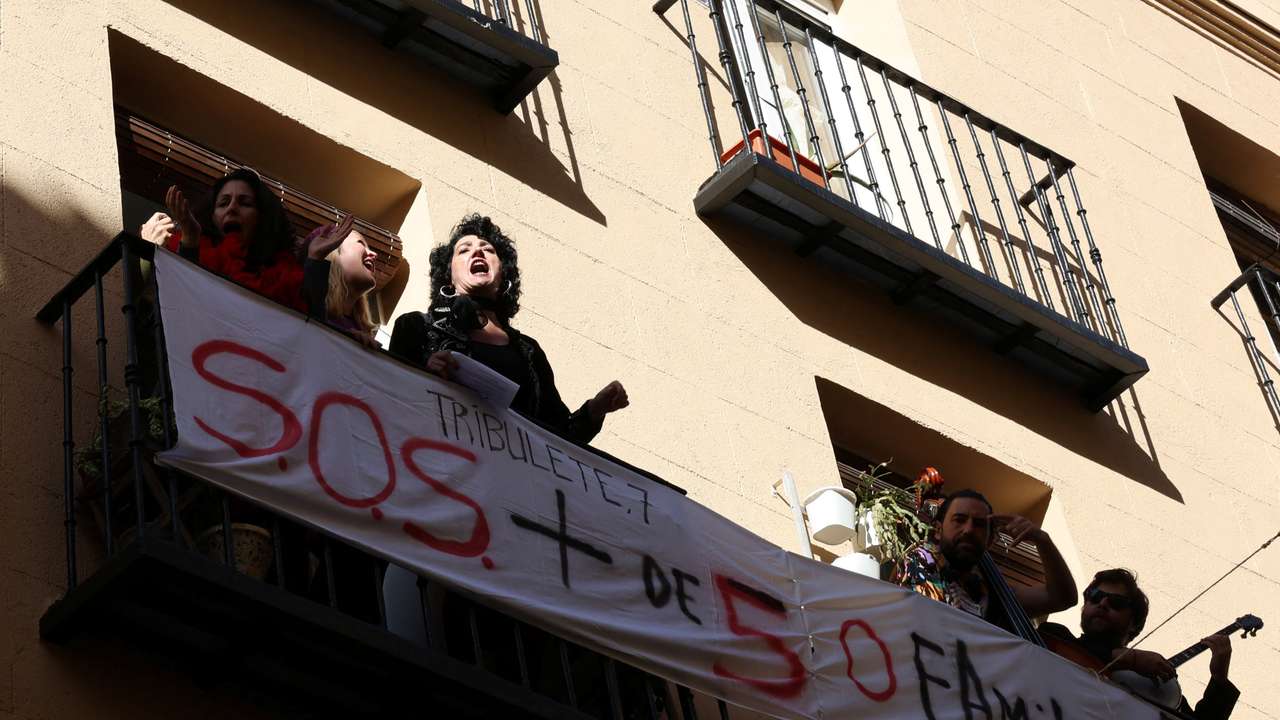 Artists perform during a protest action, in a balcony facing a building whose residents fear they will be evicted in the event of its purchase by a real estate investment fund, in Madrid
