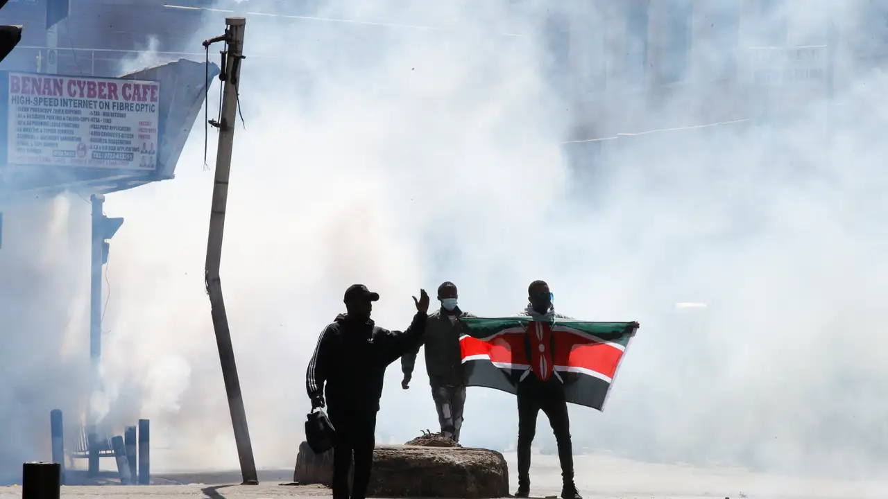 A demonstrator holds a Kenyan flag as police use tear gas to disperse protesters during a demonstration against Kenya's proposed finance bill 2024/2025 in Nairobi, Kenya, June 25, 2024. REUTERS/Monicah Mwangi