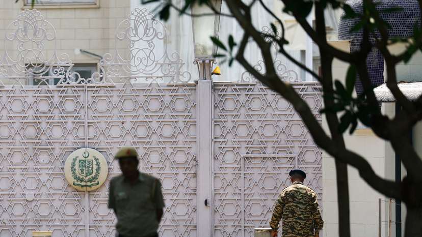 Security personnel stand outside the gate of Pakistan High Commission in New Delhi
