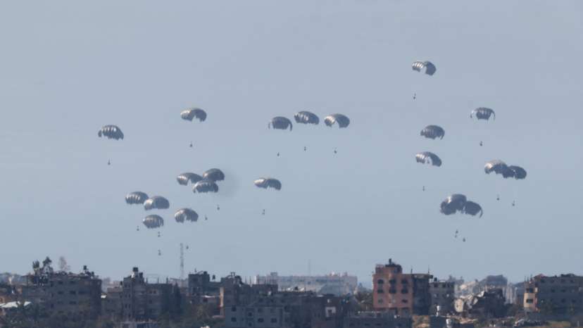 Packages dropped from a military aircraft fall towards Gaza, as seen from Israel