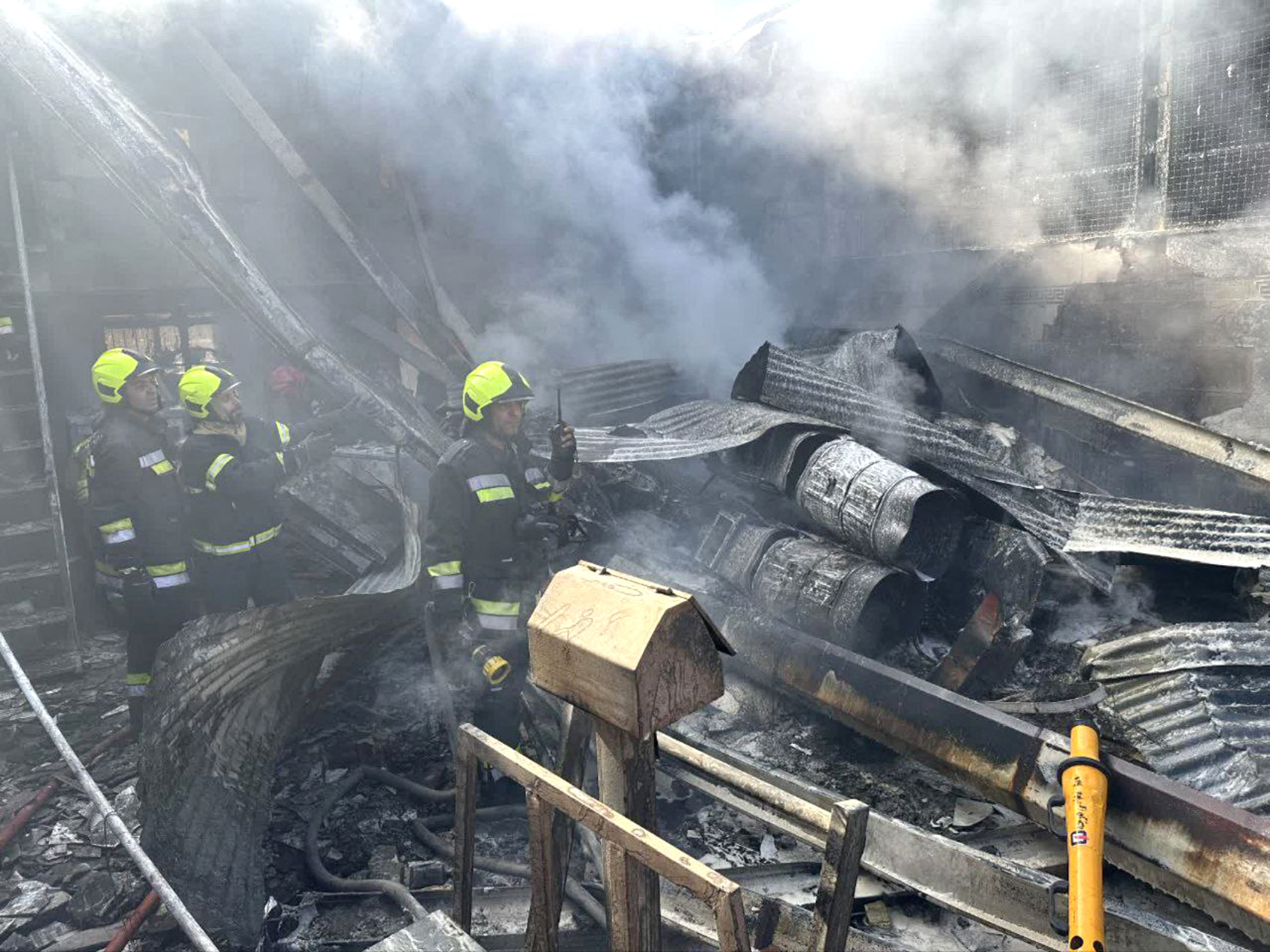 Rescue forces work at the site of an Iranian army helicopter crash in a fruit market in Isfahan