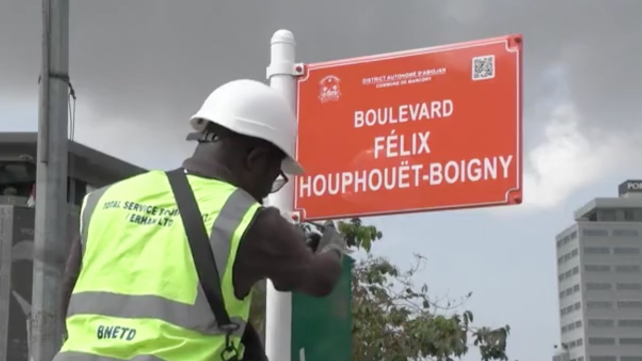 A worker fixing street names in Abijan
