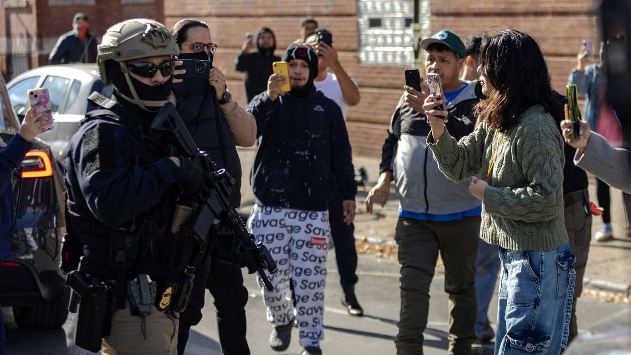 Federal agents stand off with community members during immigration raids