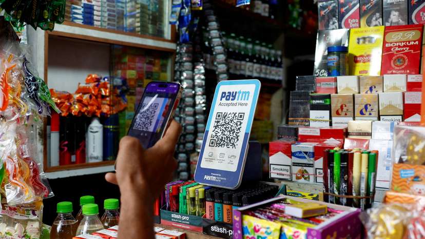 FILE PHOTO: A man uses his phone to scan a QR code of the digital payment app Paytm after purchasing a cold beverage at a shop in Kolkata