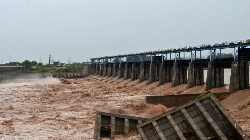 Damaged cemented blocks lie in the water beside an under-construction dam on the Tawi River, following heavy rainfall in Jammu