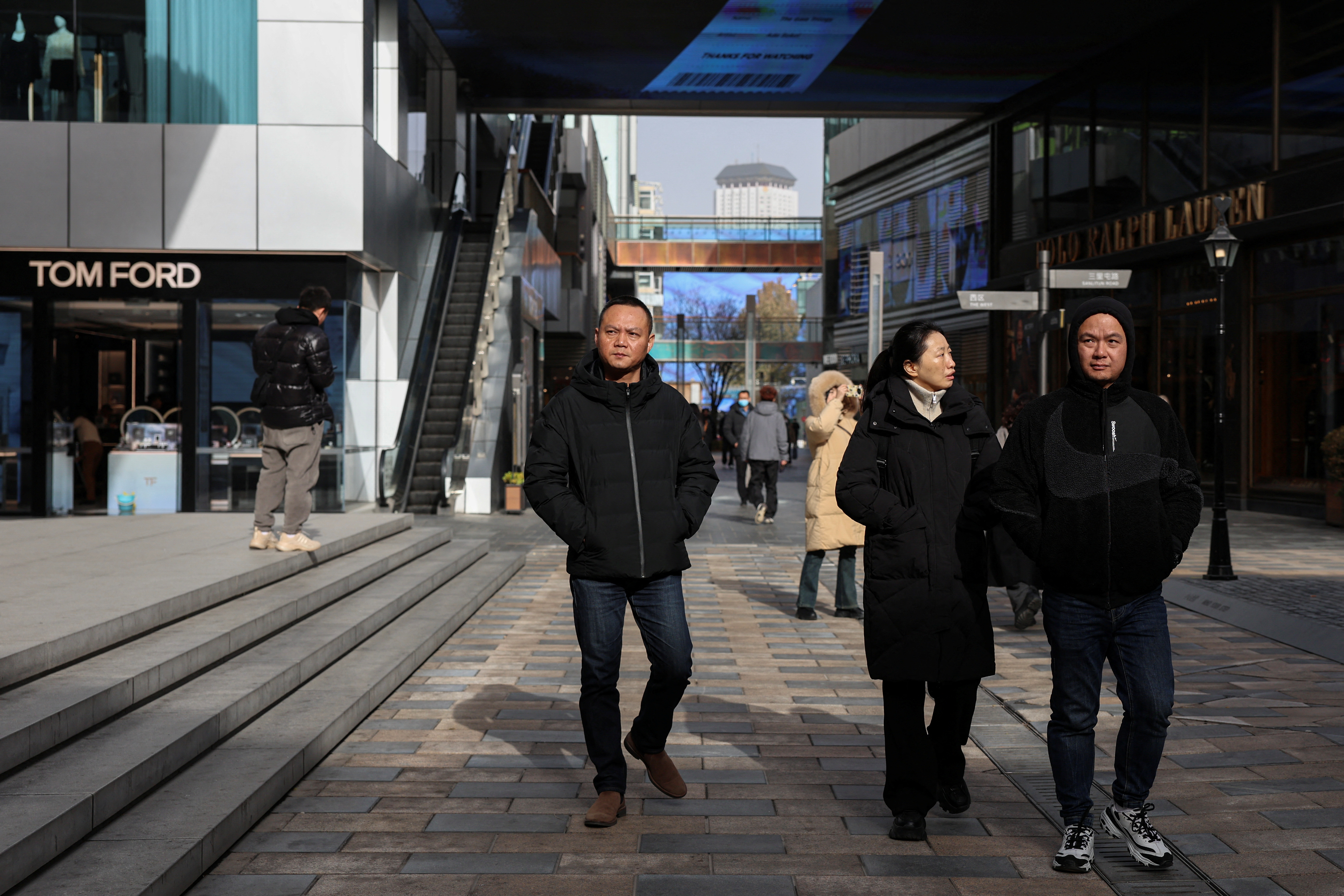 People walk at a shopping compound in Beijing