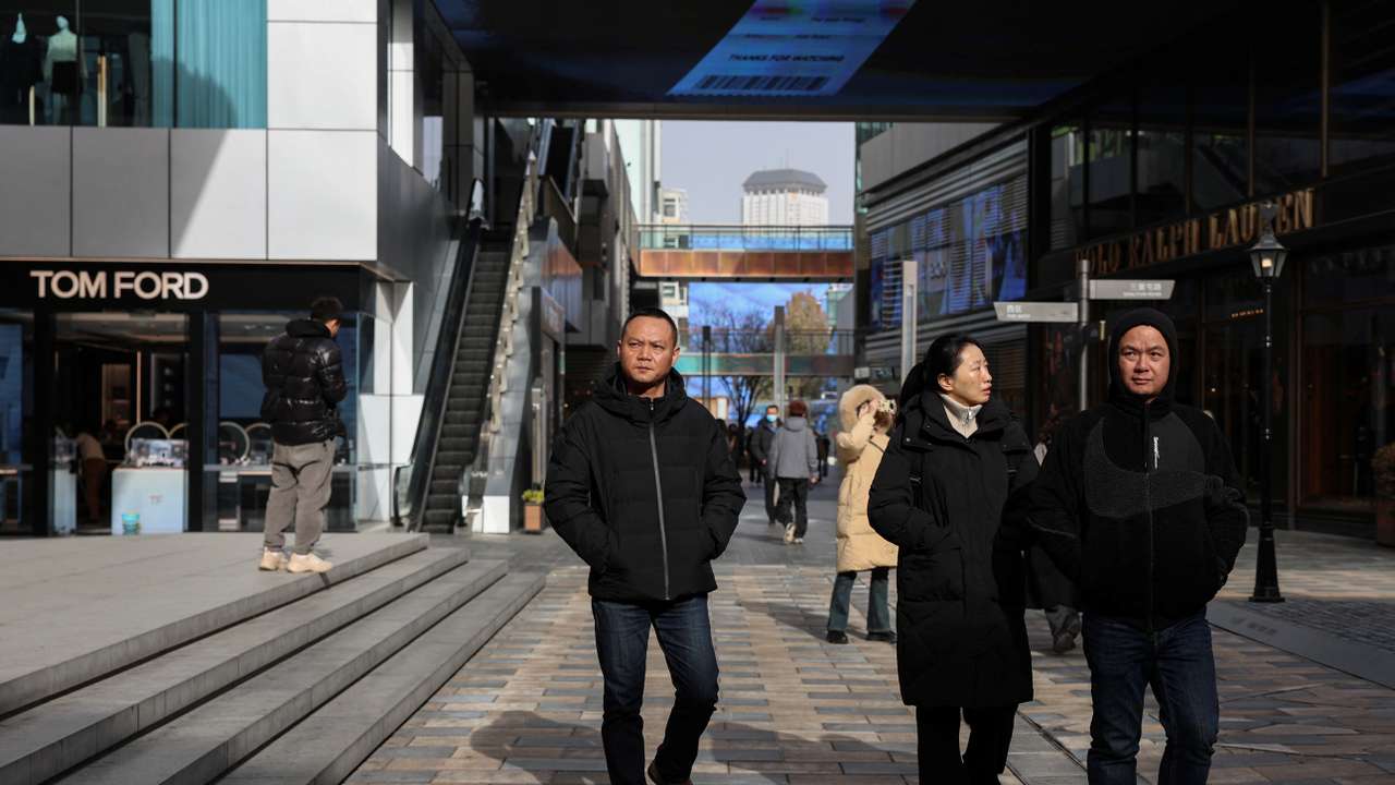 People walk at a shopping compound in Beijing