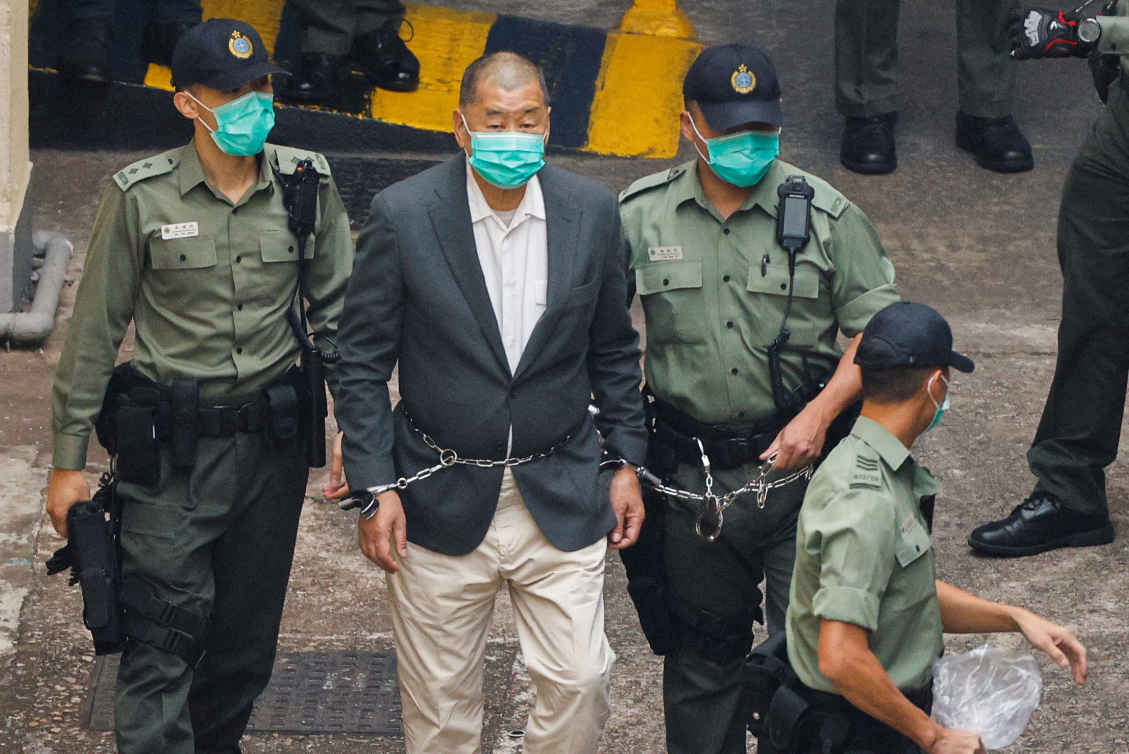 FILE PHOTO: Media mogul Jimmy Lai Chee-ying, founder of Apple Daily, walks to a prison van to head to court, after being charged under the national security law, in Hong Kong