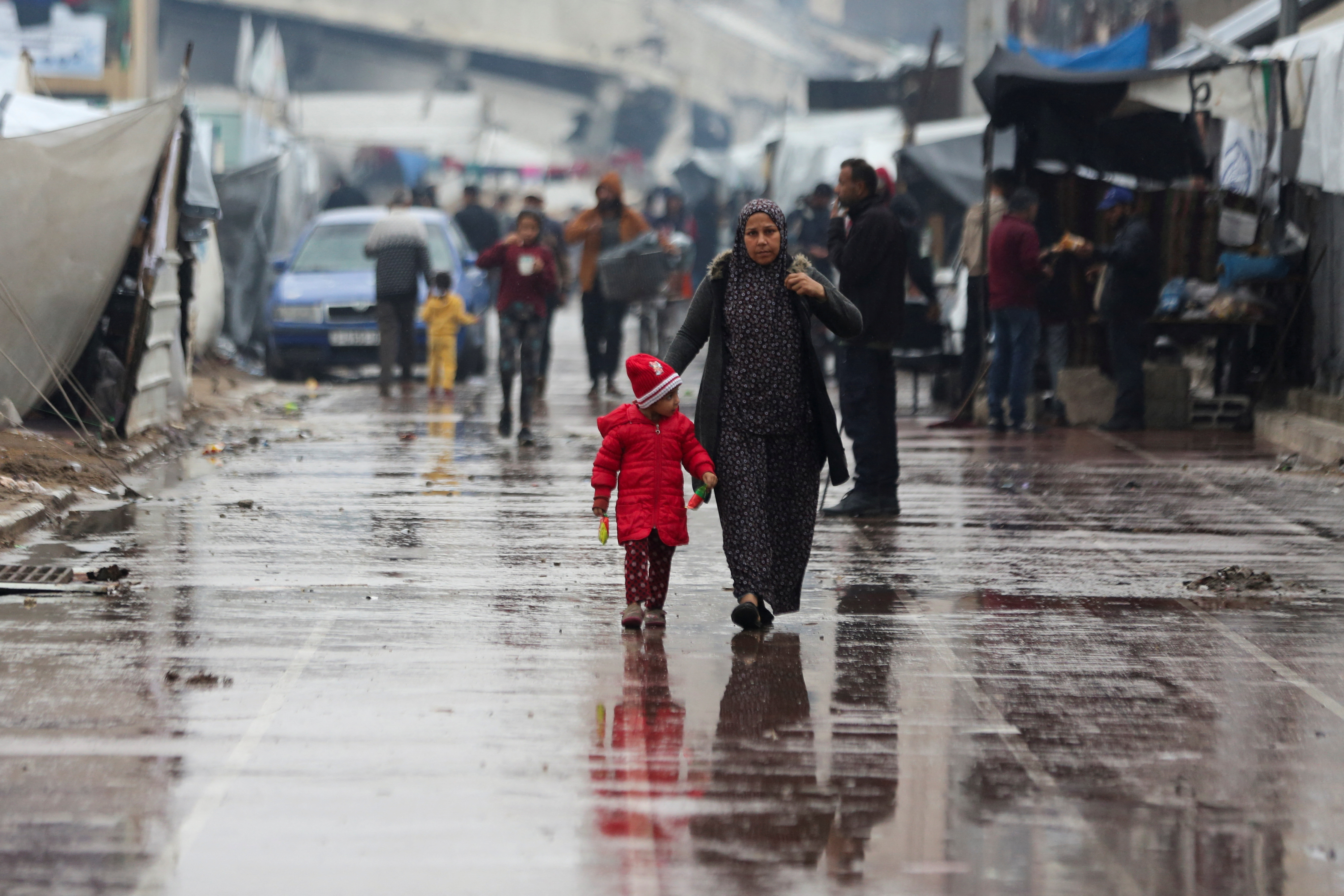 Displaced Palestinians fix their tents following rainfall, in Gaza City