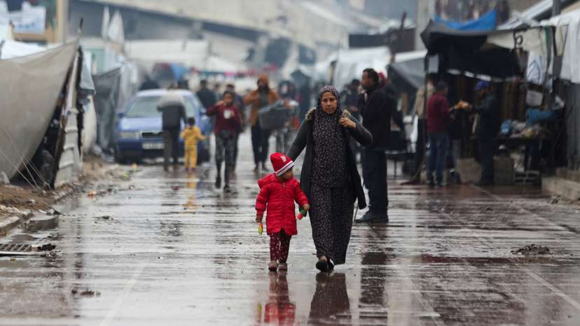 Displaced Palestinians fix their tents following rainfall, in Gaza City
