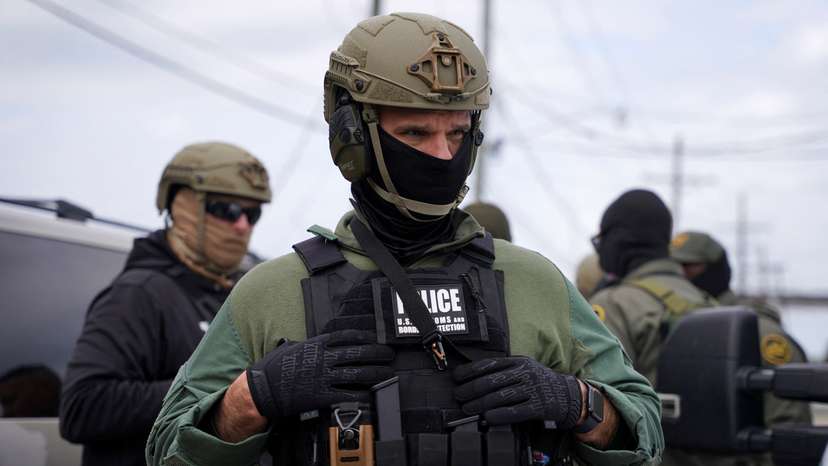 Border Patrol commander Greg Bovino and Border Patrol agents stand on a side street in Kenner