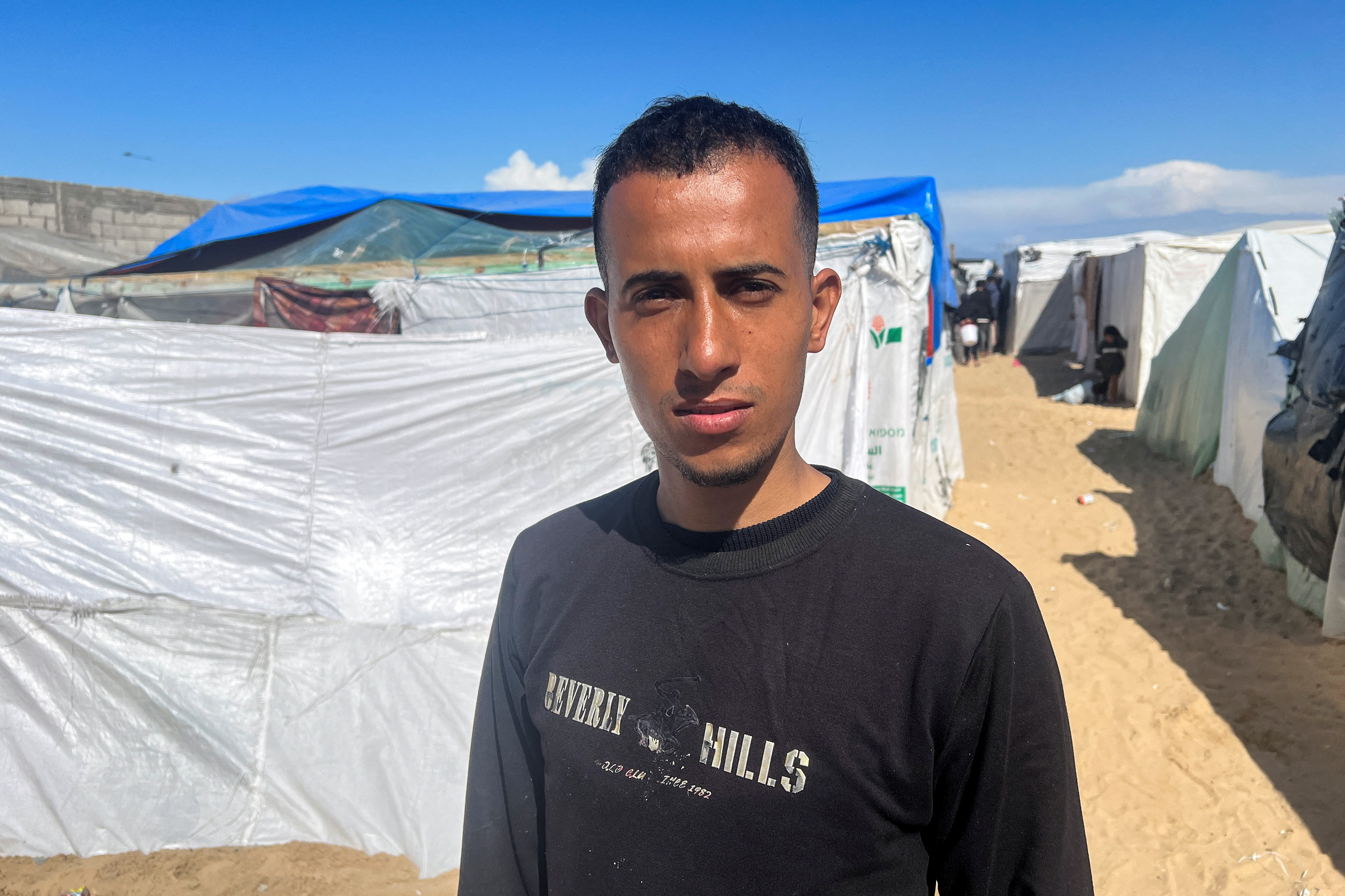 Displaced Palestinian man Youssef Shalha, who is engaged to Bisan Badah, looks on outside his tent in Rafah