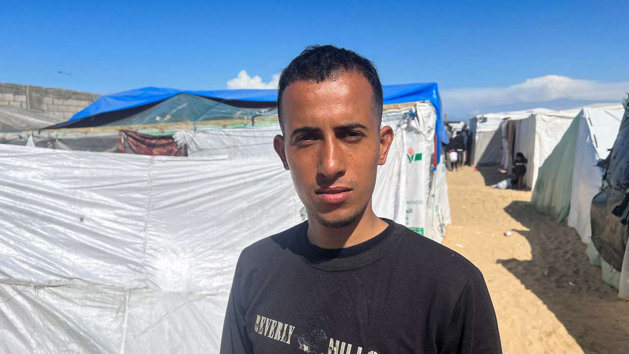 Displaced Palestinian man Youssef Shalha, who is engaged to Bisan Badah, looks on outside his tent in Rafah
